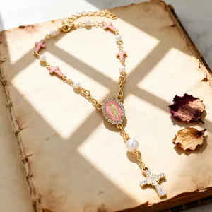 Religious rosary necklace with pink enamel crosses and pearl beads on vintage book