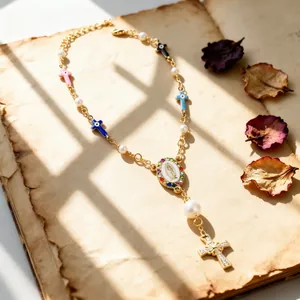Detail of vintage rosary necklace with faux pearls and enameled Mary pendant