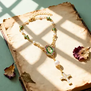 Religious rosary necklace with green enamel crosses and white pearls on vintage books