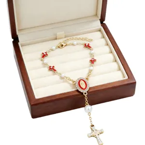 Golden religious rosary bracelet with white pearls, red enamel medals and cross pendant
