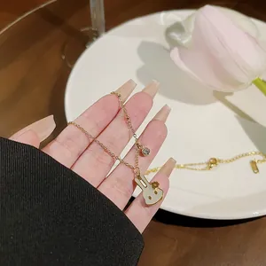Elegant gold chain necklace featuring a white rabbit pendant and small crystal charm
