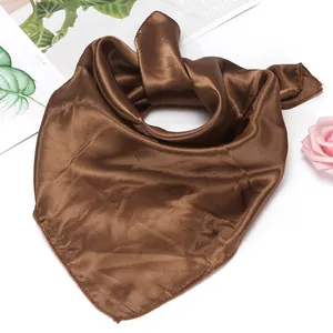 Detail of a brown satin square scarf with neat edges and a premium glossy finish
