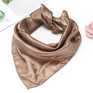 Detail of a brown satin square scarf with a glossy finish and fine hemmed edges