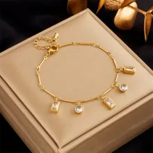 Detail of gold multilayer beaded chain bracelet with geometric zircon pendants