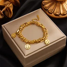 Detail of gold double-layer chain bracelet featuring three smiley face pendants