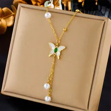 Detail of golden butterfly pendant with green gemstone, pearls and tassel chains