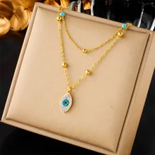 Detailed view of gold-plated double-layer necklace with blue evil eye pendant and pavé crystals