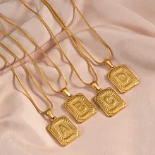 Macro detail of gold layered chains with embossed letter A B C D square pendants