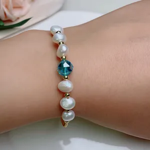 Detailed close-up of a handmade freshwater pearl bracelet featuring a blue crystal bead