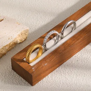 Detaillierte Nahaufnahme von drei stilvollen Edelstahlringen in Gold- und Silberoptik.
