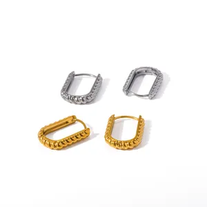 Macro view of vintage twisted stainless steel hoop earrings in gold and silver