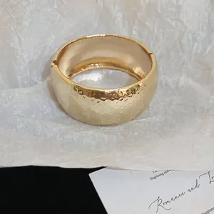 Close-up of retro hammered metal bangle in gold with vintage textured surface detail