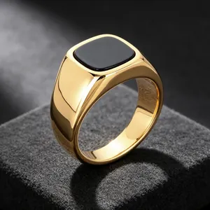 Macro detail of gold-plated signet ring featuring a polished black onyx square inlay