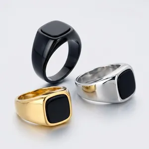 Detailed macro view of three men's stainless steel signet rings with black square inlays