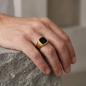 Close-up of a men's vintage gold stainless steel signet ring with black onyx stone