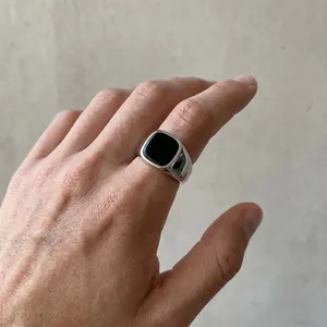 Detail of a men's vintage stainless steel ring with a square black onyx stone