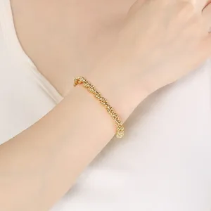 Gros plan détaillé d'un bracelet en corde torsadée dorée fait main porté au poignet