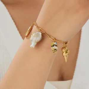 Detailed view of gold-plated stainless steel ocean charm bracelet with seashells