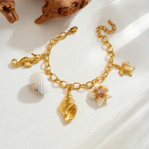 Detailed view of a gold-plated ocean charm bracelet with seahorse, shell, and turtle.
