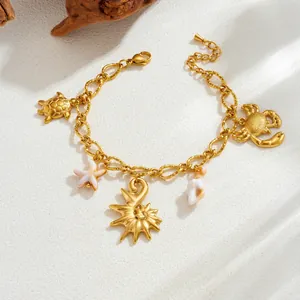 Close-up of ocean-themed turtle and starfish charms on a gold-plated stainless steel bracelet