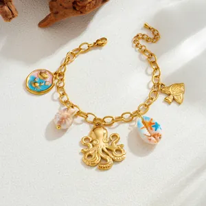 Close-up detail of gold stainless steel octopus and shell charms on beach style bracelet.