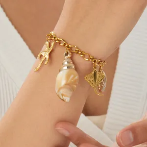 Detailed close-up of a gold-plated ocean charm bracelet featuring starfish and conch shells