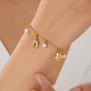 Close-up of gold-plated ocean charm bracelet featuring octopus and pearl detail