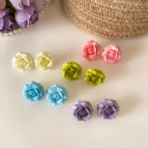 Close-up detail of elegant resin rose flower stud earrings in diverse vibrant pastel colors