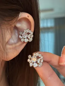 Macro detail view of elegant 18K gold plated zircon floral ear cuffs shown on model's ear