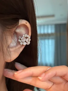 Detailed close-up view of a sparkling circular zircon ear cuff plated in 18K gold.