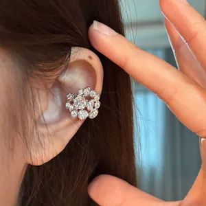 Detailed close-up of a sparkling flower-shaped cubic zirconia ear cuff on an ear