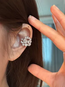 Macro shot of a luxury zircon-encrusted silver floral ear cuff on an Asian model's ear.