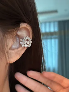 Close-up view of the sparkling floral cubic zirconia ear cuff worn on a model's ear.