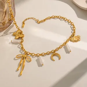 Detail view of gold-plated stainless steel necklace with pearl, butterfly and bow charms