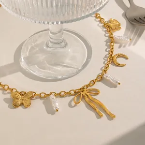 Detailed macro shot of 18K gold plated stainless steel necklace with butterfly and pearl charms