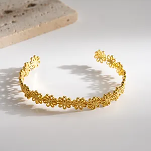 Eleganter goldfarbener Armreif mit durchbrochenem Blumenmuster und edler Textur.