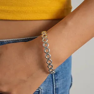 Nahaufnahme eines minimalistischen silbernen Armreifs mit hohlen kreisförmigen Gliedern