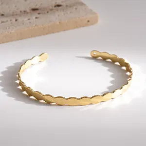 Elegante Makro-Detailansicht eines vergoldeten Armreifs mit Wellenkante für Damen