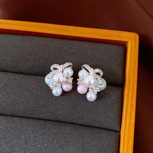 Nahaufnahme von eleganten Perlen- und Strass-Ohrringen in einem dunkelgrauen Schmucktablett.