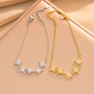 Detalle de pulseras de estrellas de ocho puntas en plata y oro con circonitas