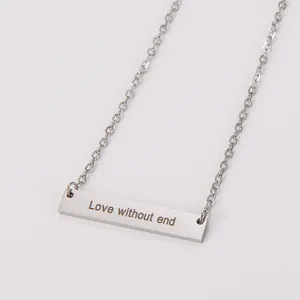 Détail d'un pendentif barre en acier inoxydable poli avec gravure Love without end.