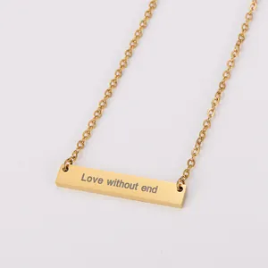 Détail du collier en barre dorée avec gravure 'Love without end' en gros plan