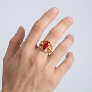 Detailed close-up of a Gothic skull coffin ring in gold finish on a male finger