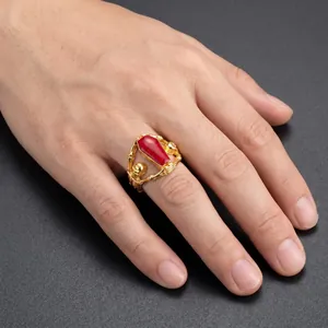 Detailed view of a Gothic dark style skull coffin ring with red epoxy resin detail on a male hand