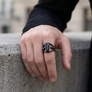 Detailed view of gothic black titanium steel coffin ring featuring skeleton hands for men