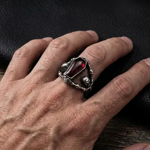 Gothic titanium steel coffin ring with red epoxy center and skull details on hand
