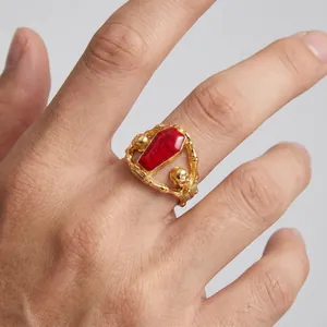 Close-up of a gothic gold titanium steel ring featuring skeletons and a red coffin