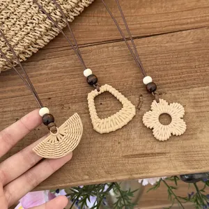 Detailed macro view of three handmade Bohemian woven pendants in fan and floral shapes on wood.