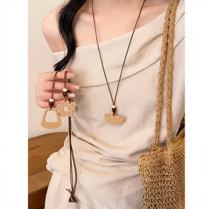 Detail view of Bohemian woven straw pendant necklace set on model.