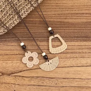 Detail view of three Bohemian woven pendants with wooden beads on a rustic wood background